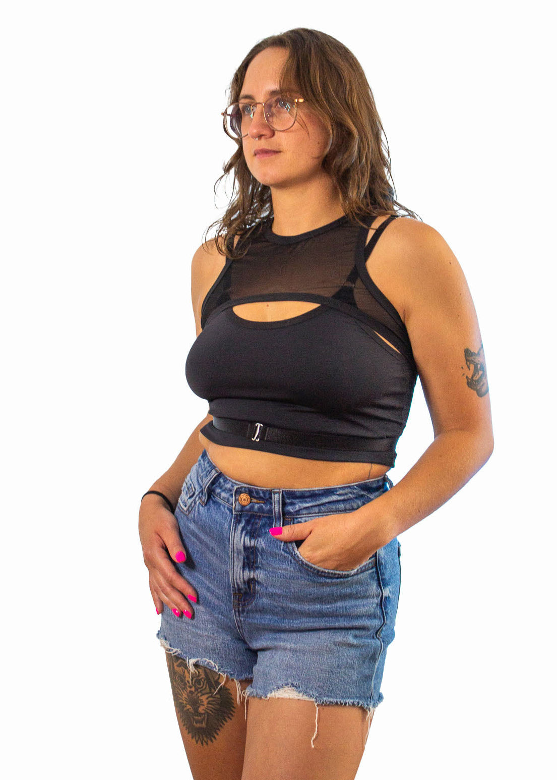 Woman wearing a black mesh top and denim shorts on a white background