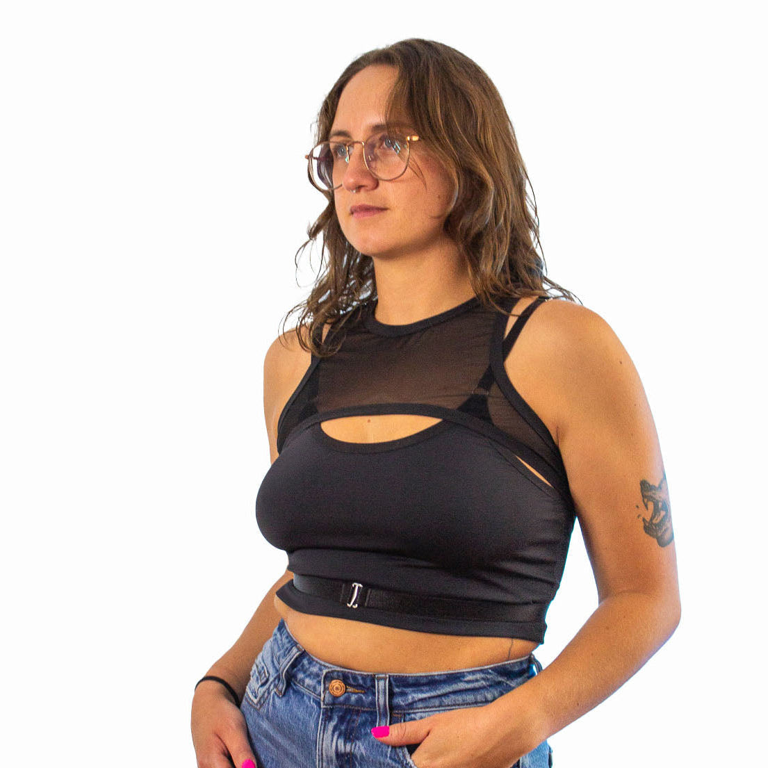 Woman wearing a black mesh top and denim shorts on a white background